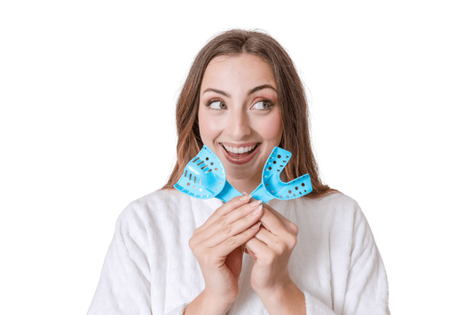 Woman smiling holding up two blue impression trays from SayCheeseClub 