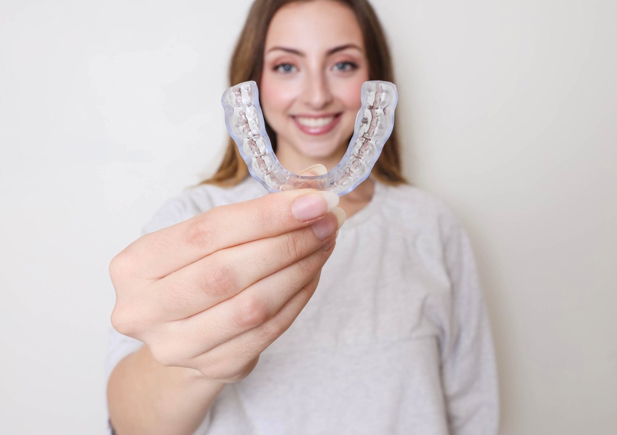 Hard Night Guard for TMJ and Brux held up by woman